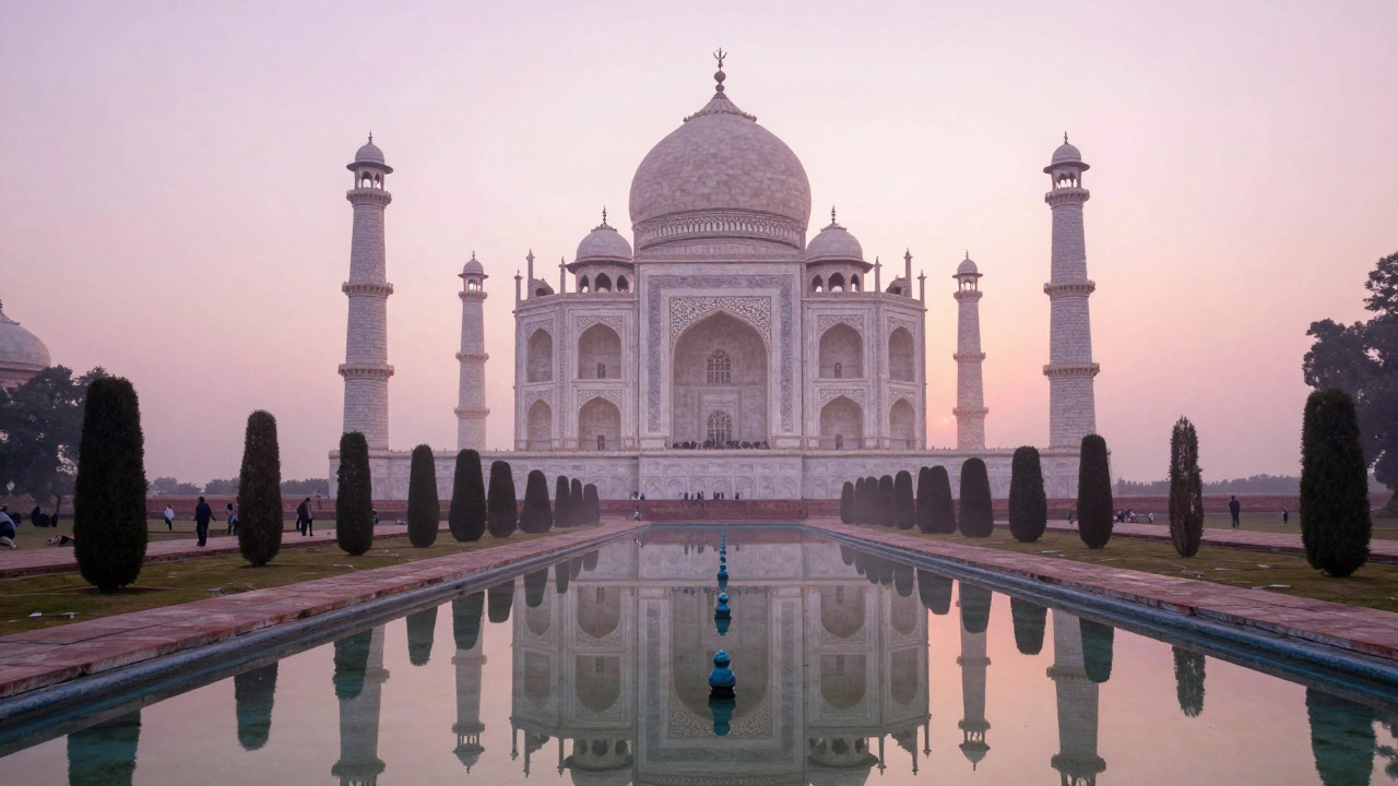 The Taj Mahal at dawn with soft pink light reflecting in the water